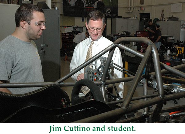 Professor and student looking at race car