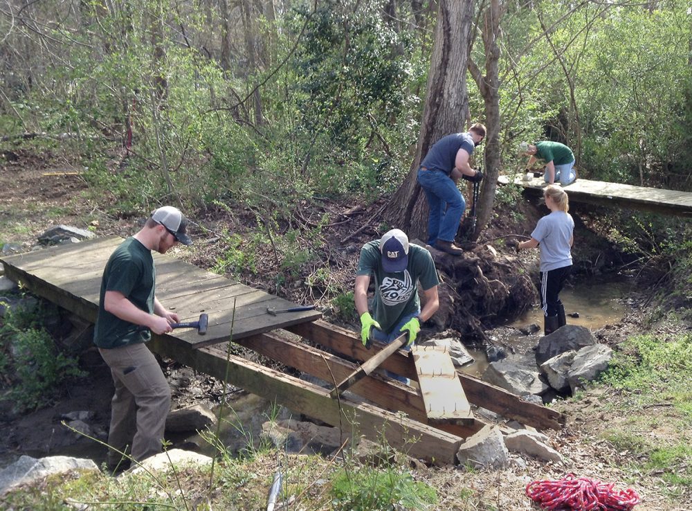 Leadership Academy students working on a small wooden bridge