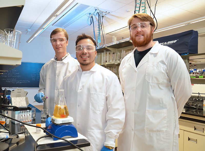 Nathan Lindolm, Bryan Moreno and Michael Murray working with brewer's yeast.