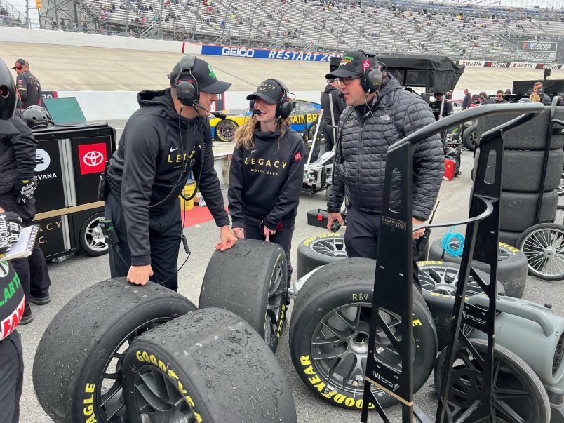 Sydney Prince speaks with fellow crew members about Jimmie Johnson's tires