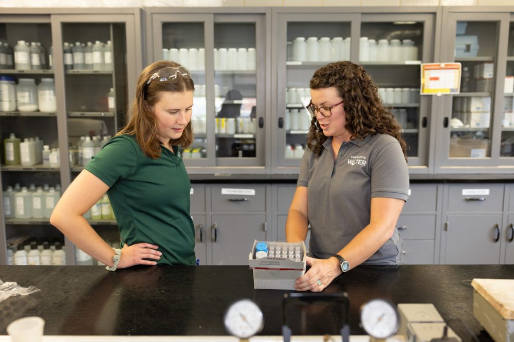 Two people looking at water samples for testing