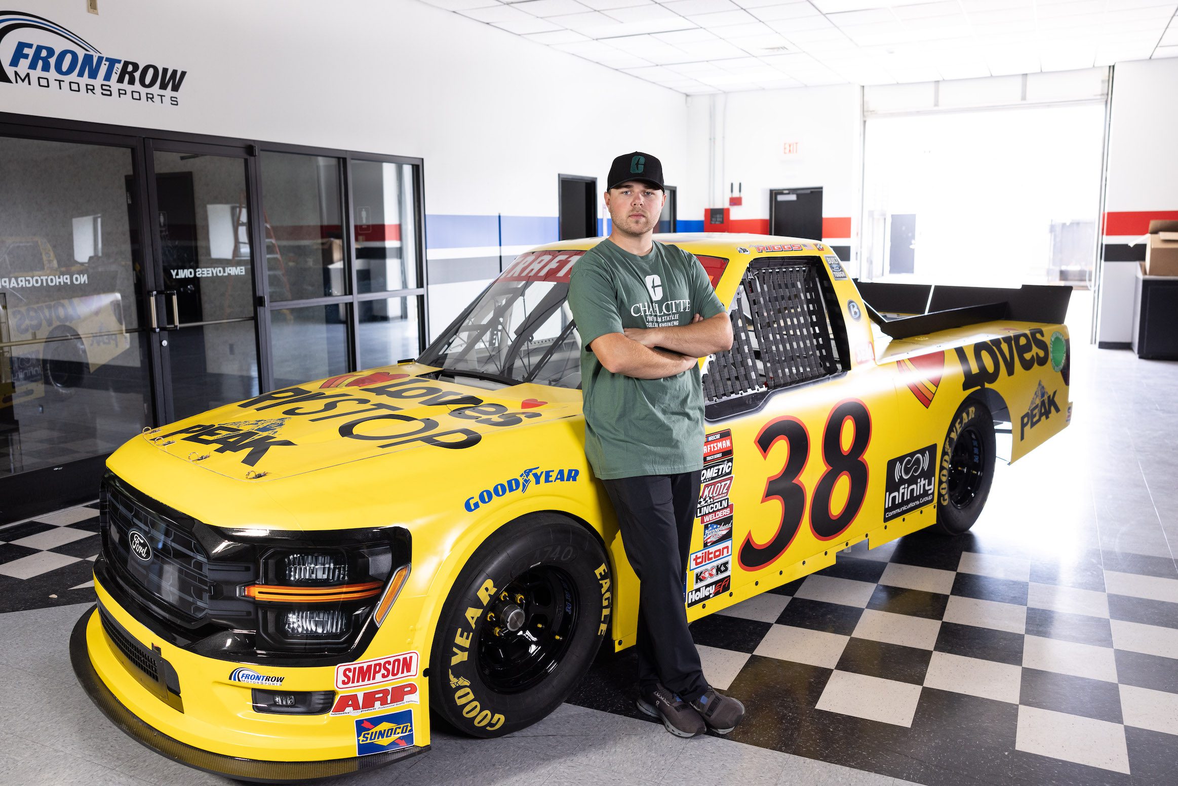 Layne Riggs standing beside his race truck