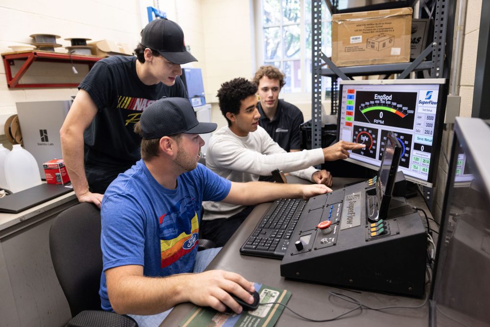 Layne Riggs and other engineering students looking at data on computer