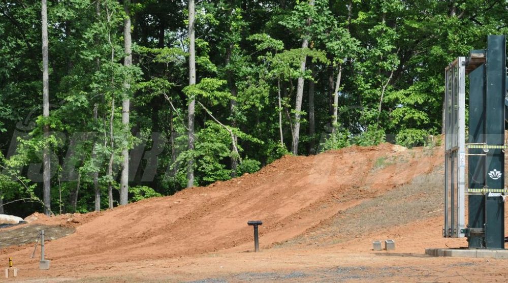 Pile of dirt with trees behind it