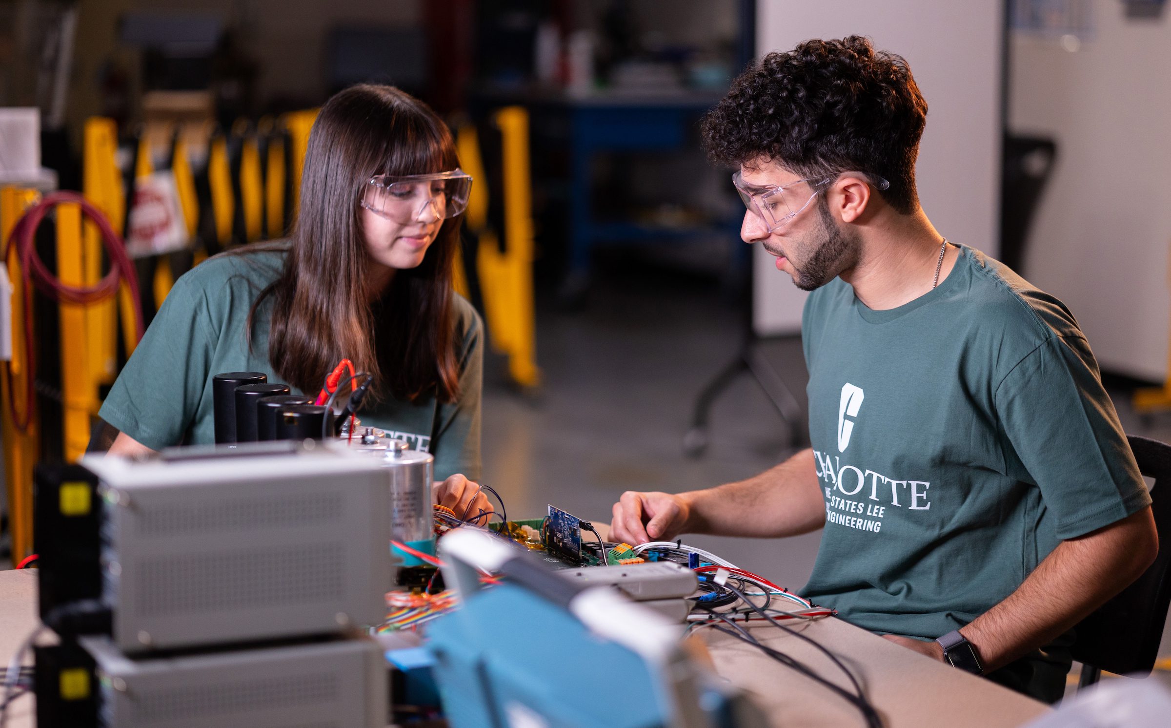 Two students sitting at a table working on an electrical project 