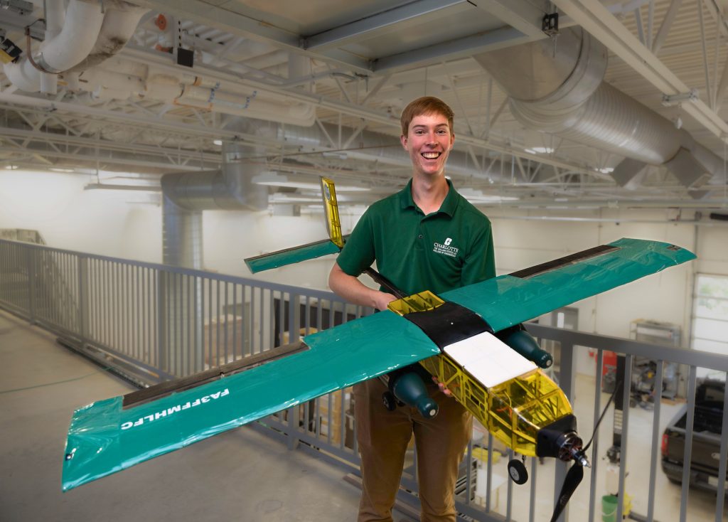 Student with the Design-Build-Fly aircraft that he and the team developed and flew in the April 2025 international competition.