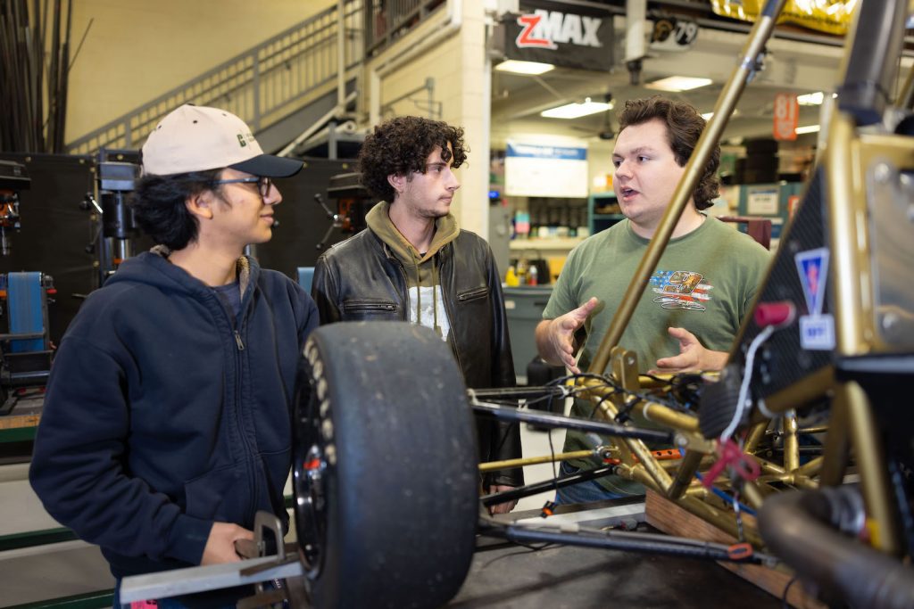 Students stand near race car in Kulwicki Motorsports Lab