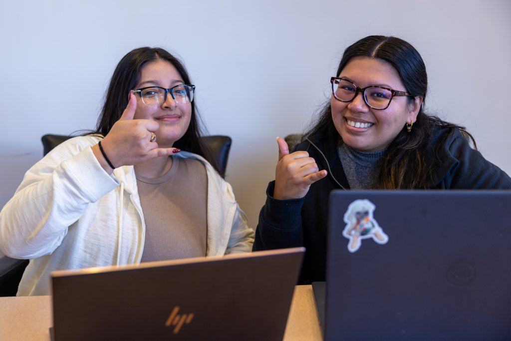 Two students showing pick axe hand signs