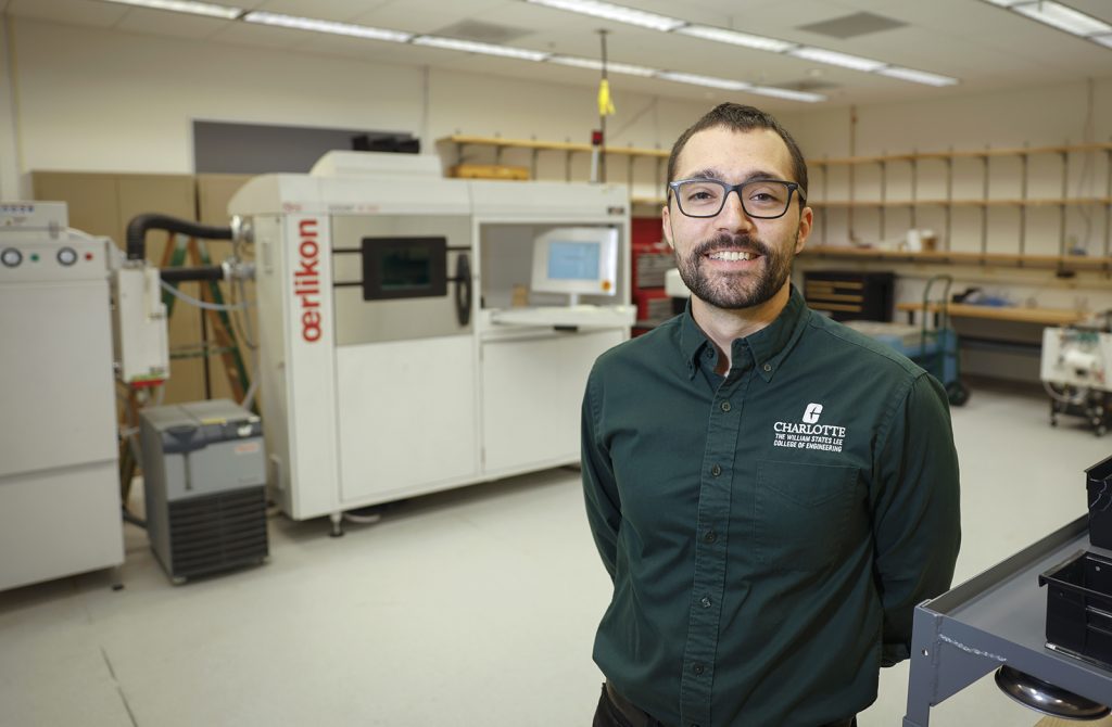 Professor stands in front of Oerlikon AM additive manufacturing machine