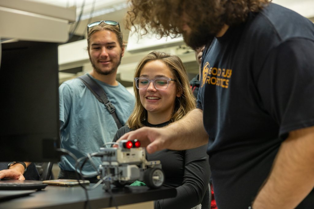 Students sitting at desk with robotic vehicle