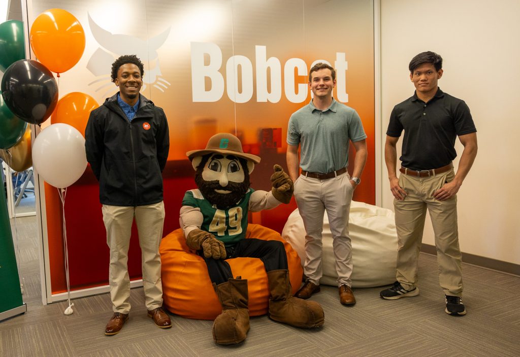 Students standing next to Norm the Niner at the Bobcat Student Center