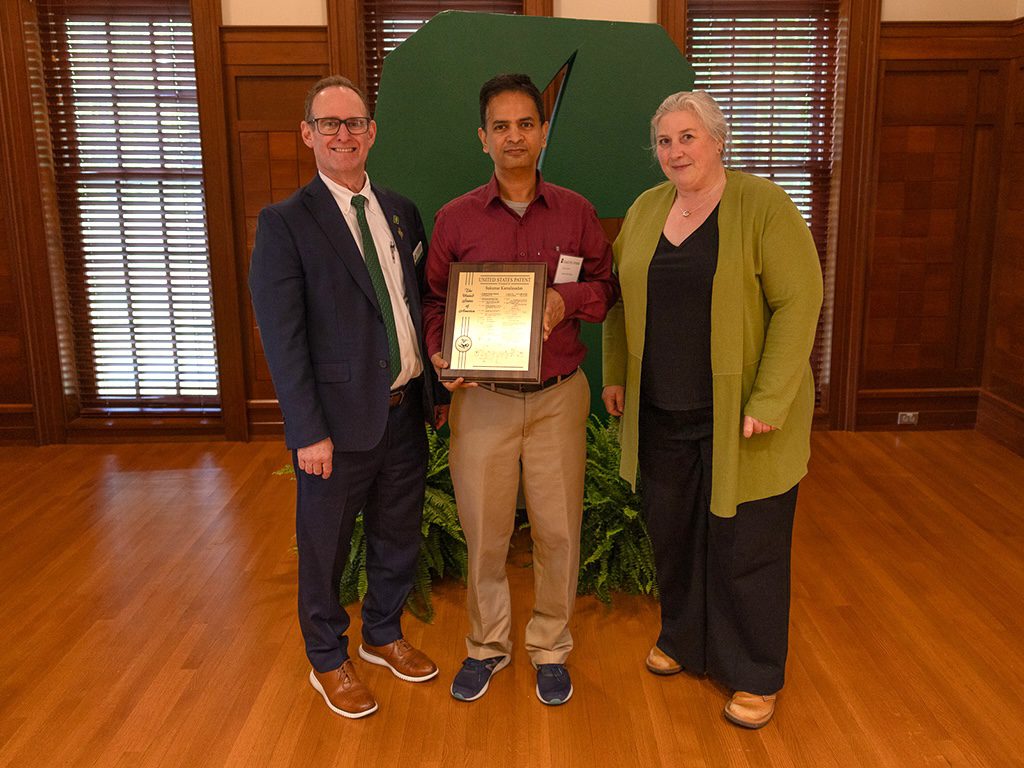 Dean Rob Keynton and Associate Dean for Research Brigid Mullany presenting award to Sukumar Kamalasadan