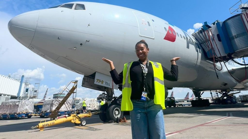 Charlotte engineering student Myla Marve standing in front of airplane at Charlotte-Douglas International Airport