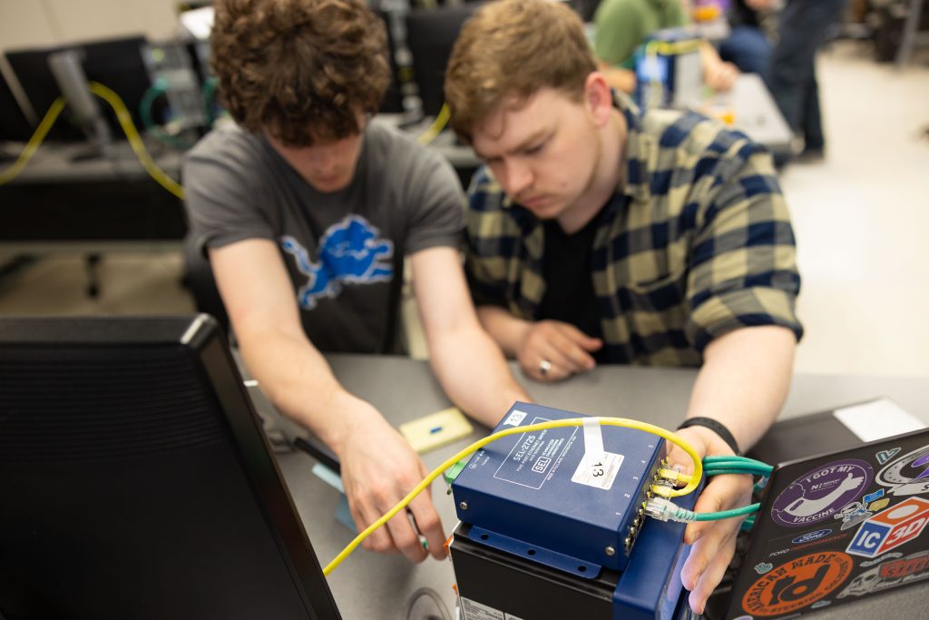Two students work with machinery.