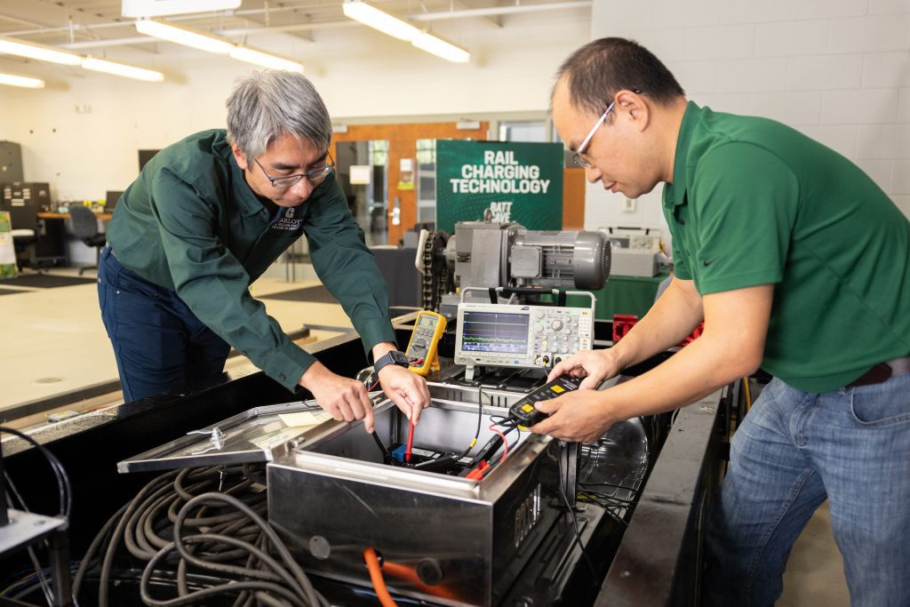Professor and student working on rail charging technology in BATT CAVE