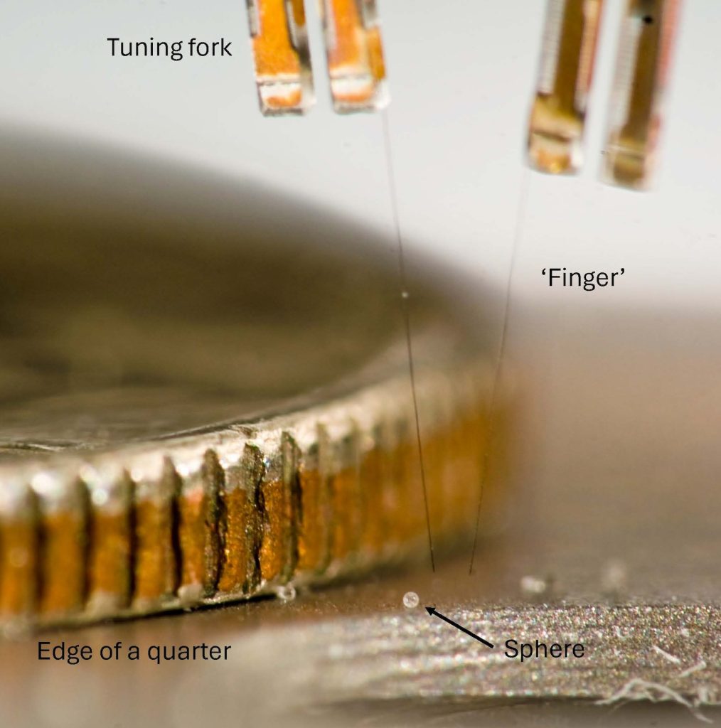 Close-up of three-fingered self-sensing micro-robotic assembly tool