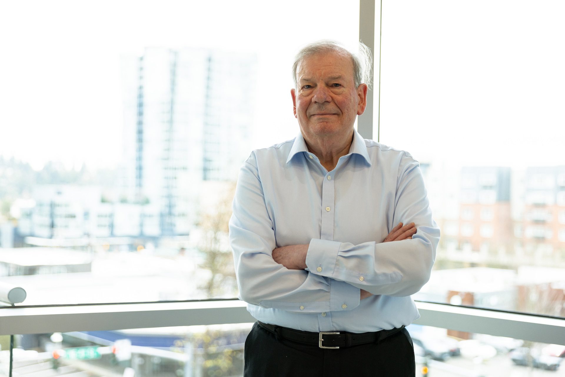 Portrait of Graham Siddall smiling, standing with his arms crossed