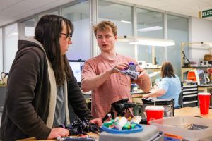 Two students examine a battle bot in UNC Charlotte's Super Fab Lab