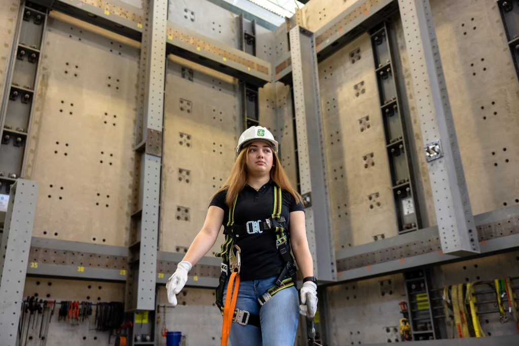 student walks in hardhat through highbay lab